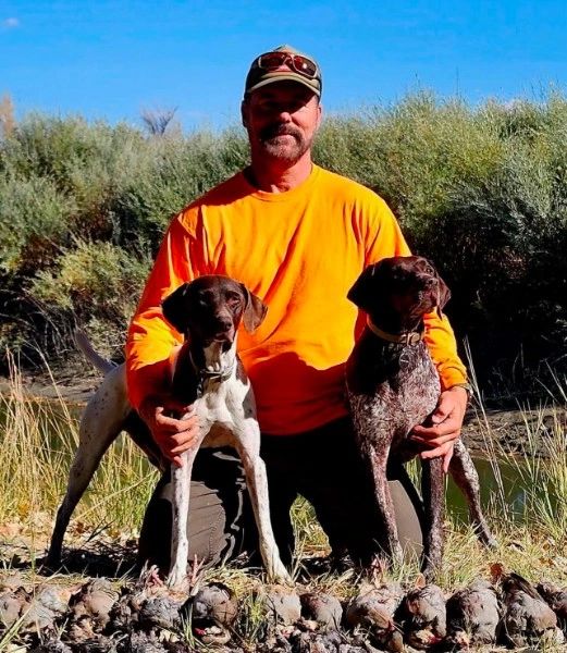Man posing with two dogs outdoors — Kona